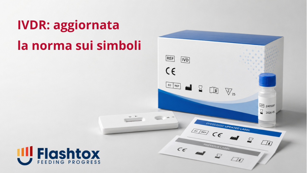 kit diagnostico in vitro con confezione, flaconcino, dispositivo di test e fogli di etichettatura aggiornati. Il riferimento visivo è alla EN ISO 15223-1:2021/A1:2025, cioè alla norma sui simboli da utilizzare nelle informazioni fornite dal fabbricante. In sovrimpressione la scritta "IVDR: aggiornata la norma sui simboli".